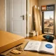 Pasillo de apartamento en Barcelona con puerta de interior nueva, herramientas y luz cálida; "Donde puedo comprar puertas de interior con instalacion incluida en Barcelona".